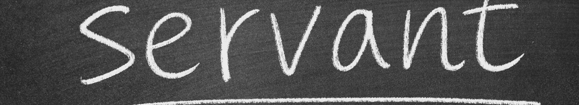 The word 'servant' is written in white chalk on a dark, textured blackboard.